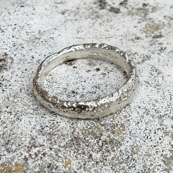 silver textured ring on grey stone background