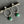 Silver hoop earrings with green gemstones on a gray surface