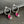 Pair of silver hoop earrings with pink gemstones on a dark surface