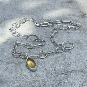 handmade silver chain with yellow aquamarine on grey background