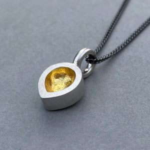 Necklace with a pendant featuring a gold interior on a gray background