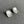 Silver flower-shaped earrings on a gray surface